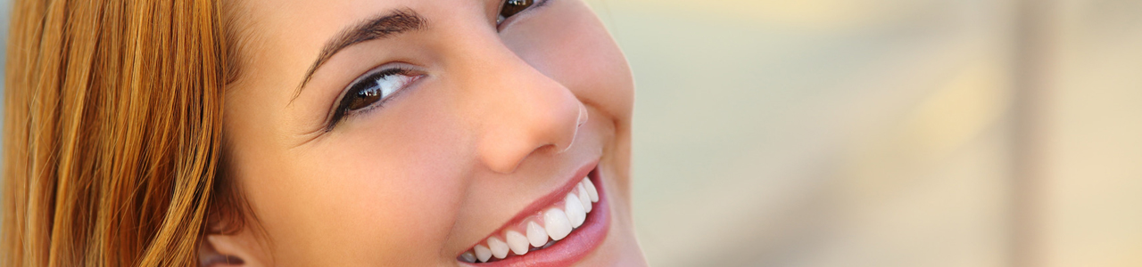 Eine Frau lacht und zeigt dabei ihre schönen Zähne